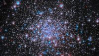 Thousands of glowing white and blue stars with a denser cluster towards the center of the image. 