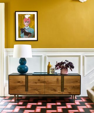 hallway with mustard yellow wall and white wood paneling