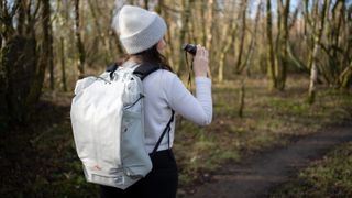 woman wearing the peak design outdoor backpack in a nature reserve
