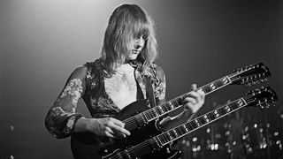 Guitarist Alex Lifeson from the Canadian band Rush performs live on stage playing a Gibson EDS-1275 twin neck/double-neck guitar at the McMorran Arena in Port Huron, USA during their All the World's a Stage tour on 22nd May 1977