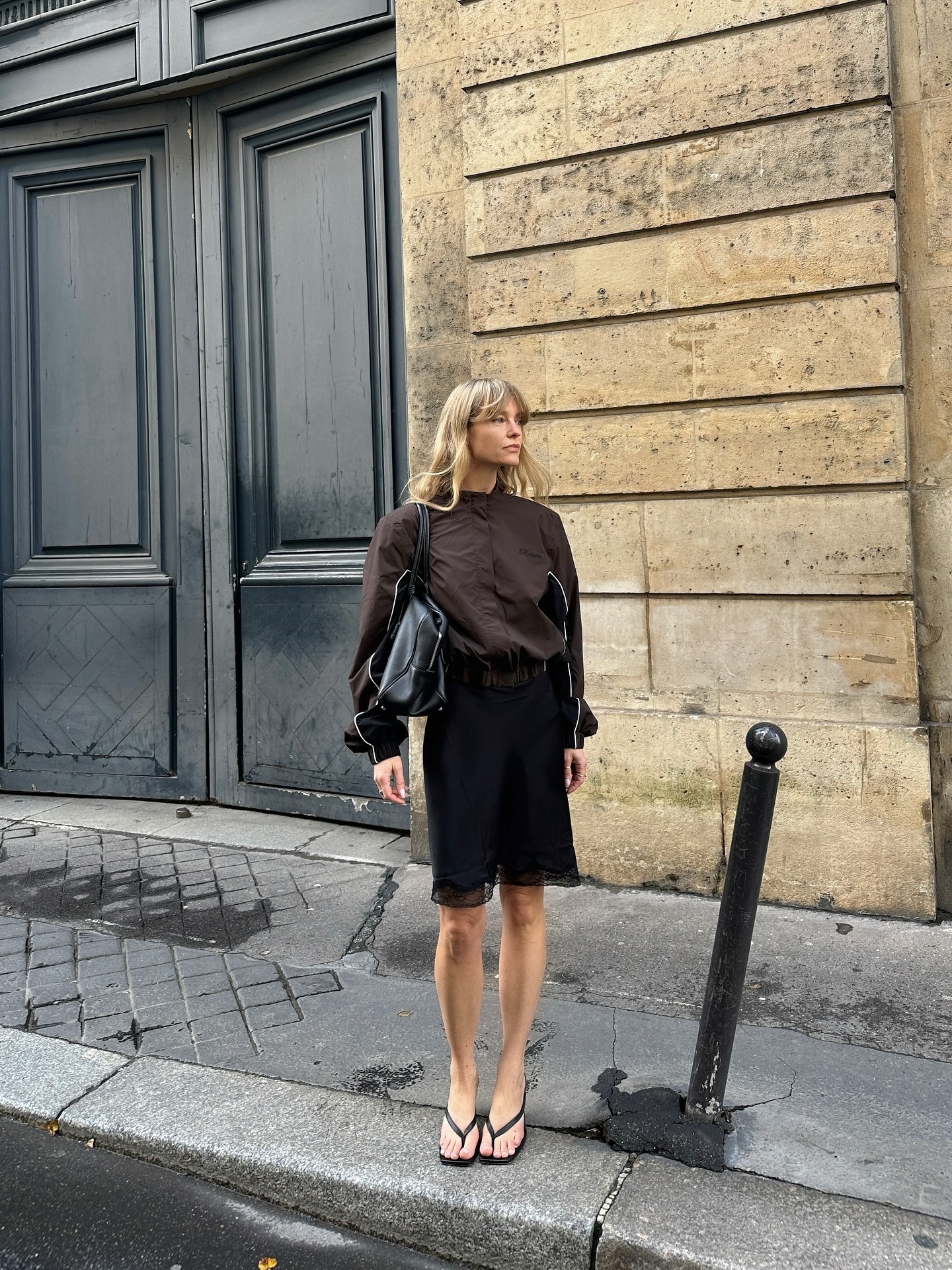 Influencer Jeanette Madsen in a high-neck tech jacket and knee-length slip skirt.