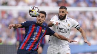 Eric Garcia (L) of FC Barcelona competes for the ball with Karim Benzema (R) of Real Madrid CF