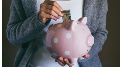 a woman depositing dollar bills into a piggy bank