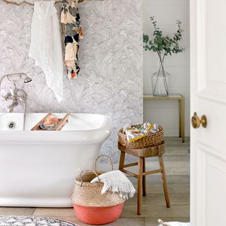 bathroom with bathtub wooden flooring and wallpaper on wall