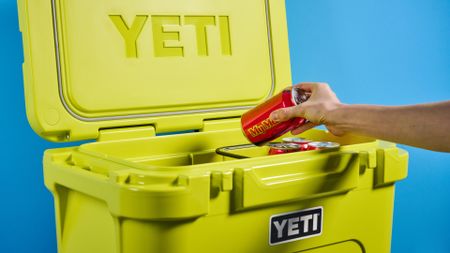 the yeti roader cooler in neon yellow with wheels, soft close hinges, a retractable handle, and 32 quart capacity