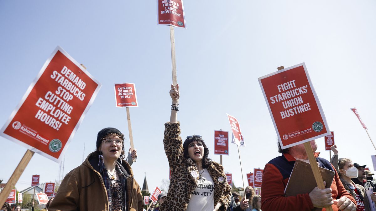 People raise picket signs during the &quot;Fight Starbucks&#039; Union Busting&quot; rally and march in Seattle, Washington on April 23, 2022.