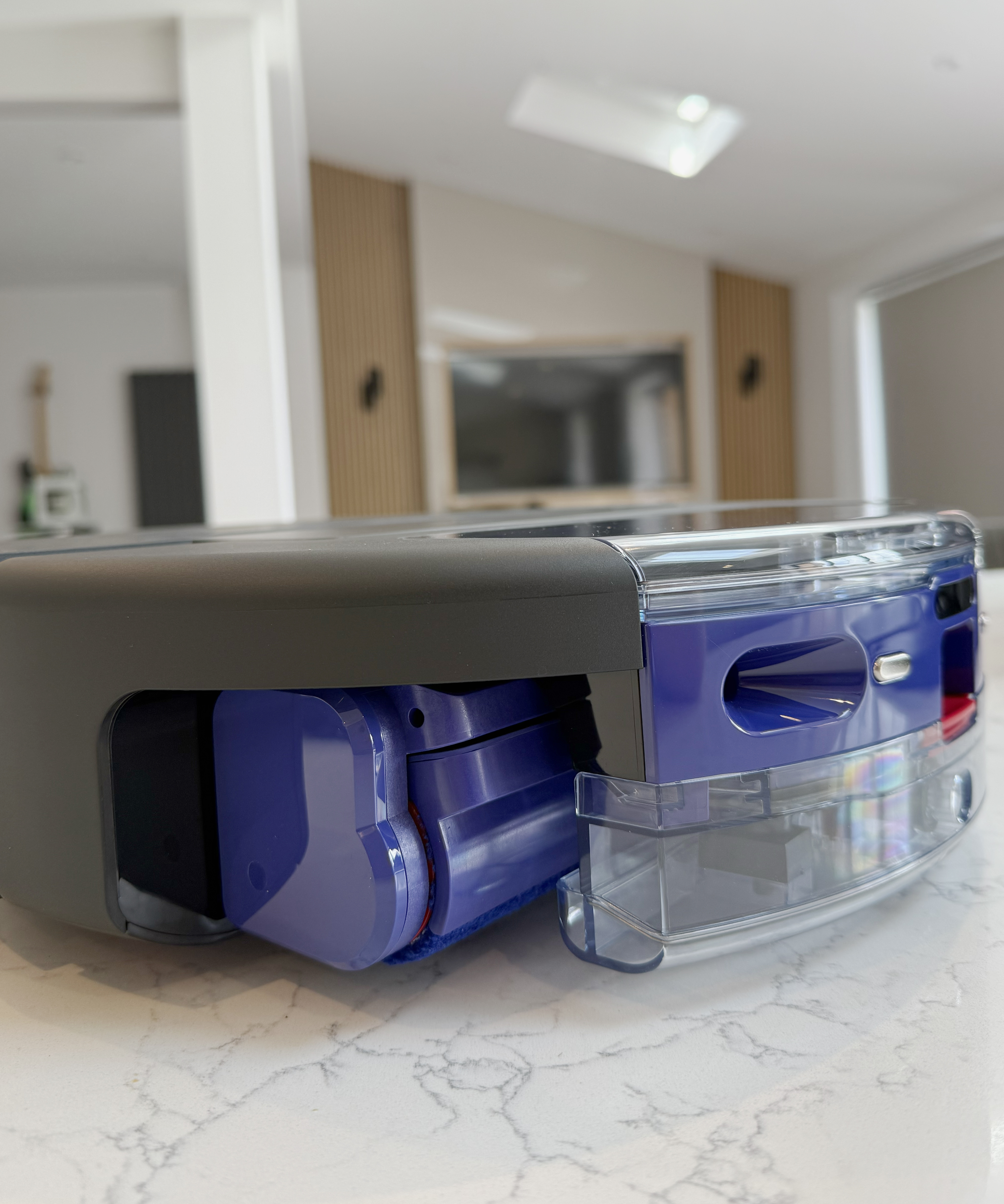 Side profile of the Dyson Spot+Scrub Ai showing the wet roller housing and camera module