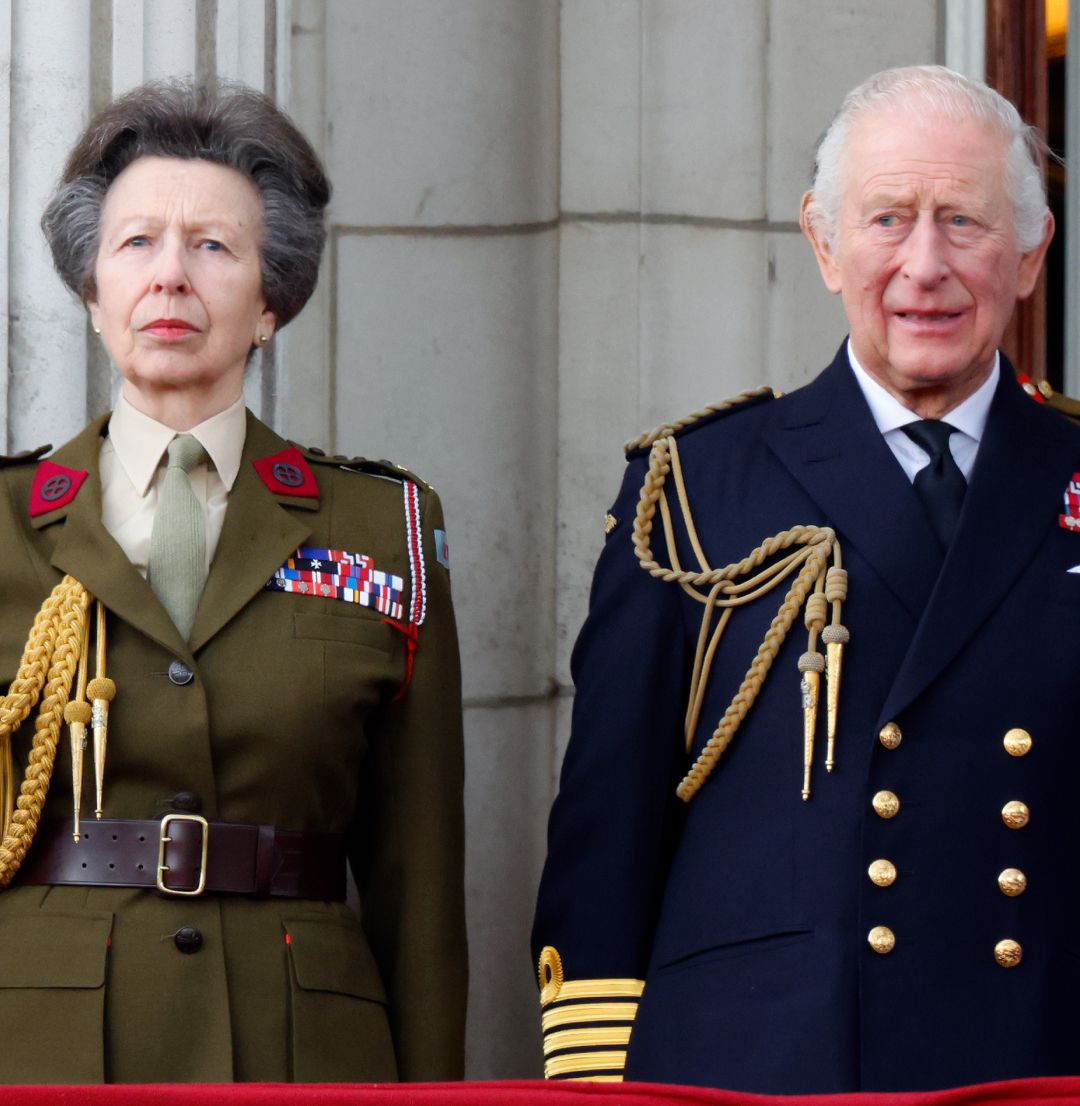 Princess Anne standing next to King Charles in military uniforms