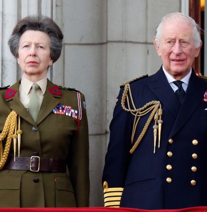 Princess Anne standing next to King Charles in military uniforms