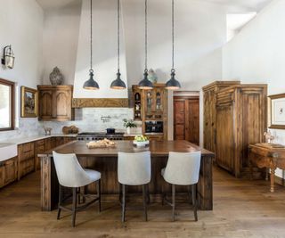 open plan kitchen with brown wood cabinets and dark wood beams and with white walls