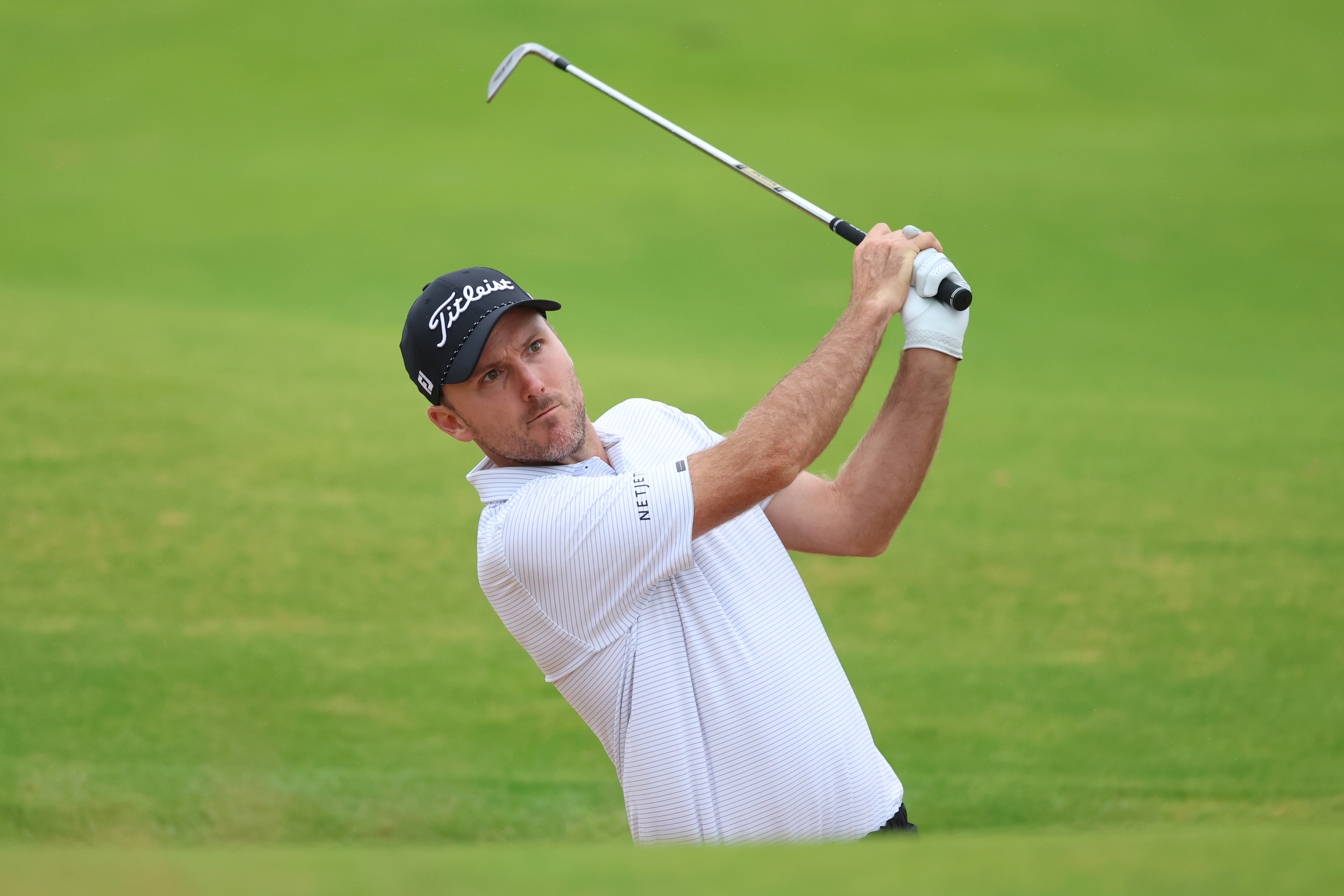 Russell Henley hits a wedge shot from a bunker