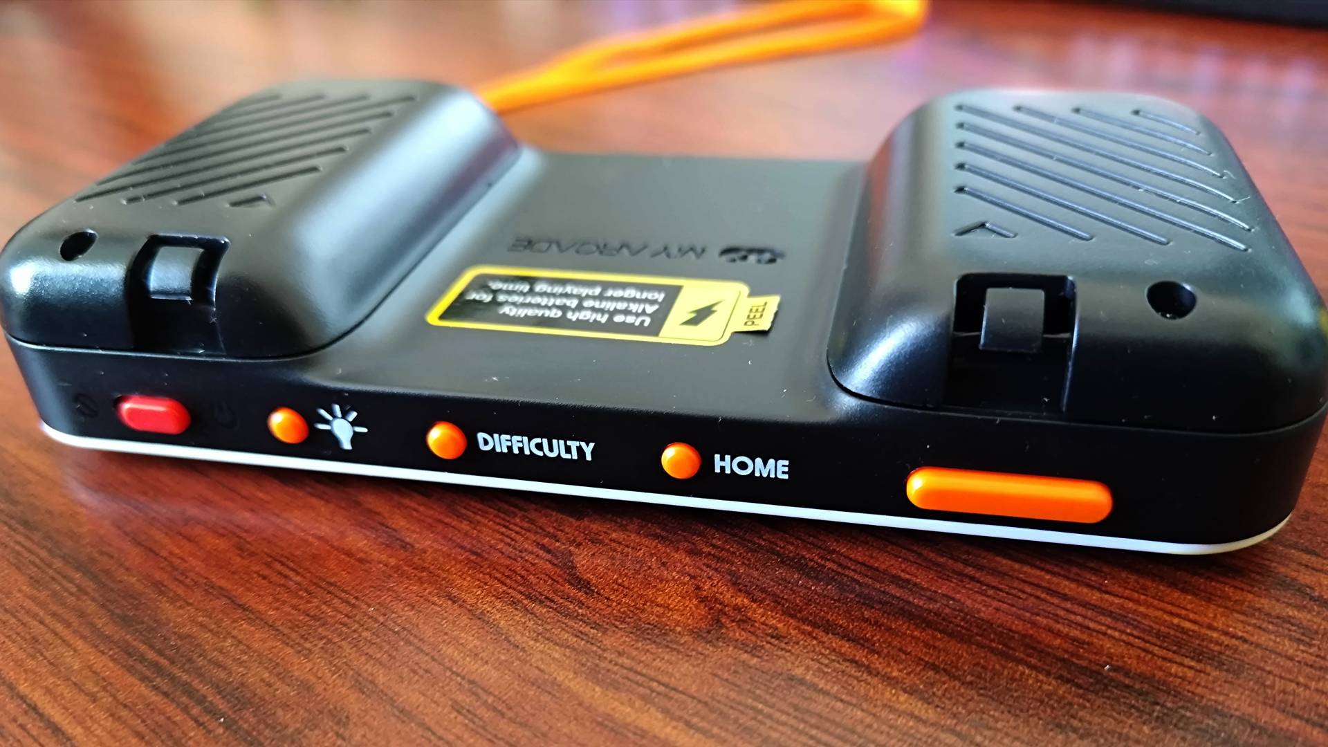 Top view of Atari Pocket Player Pro handheld power, brightness, difficulty, and home buttons next to volume toggle.