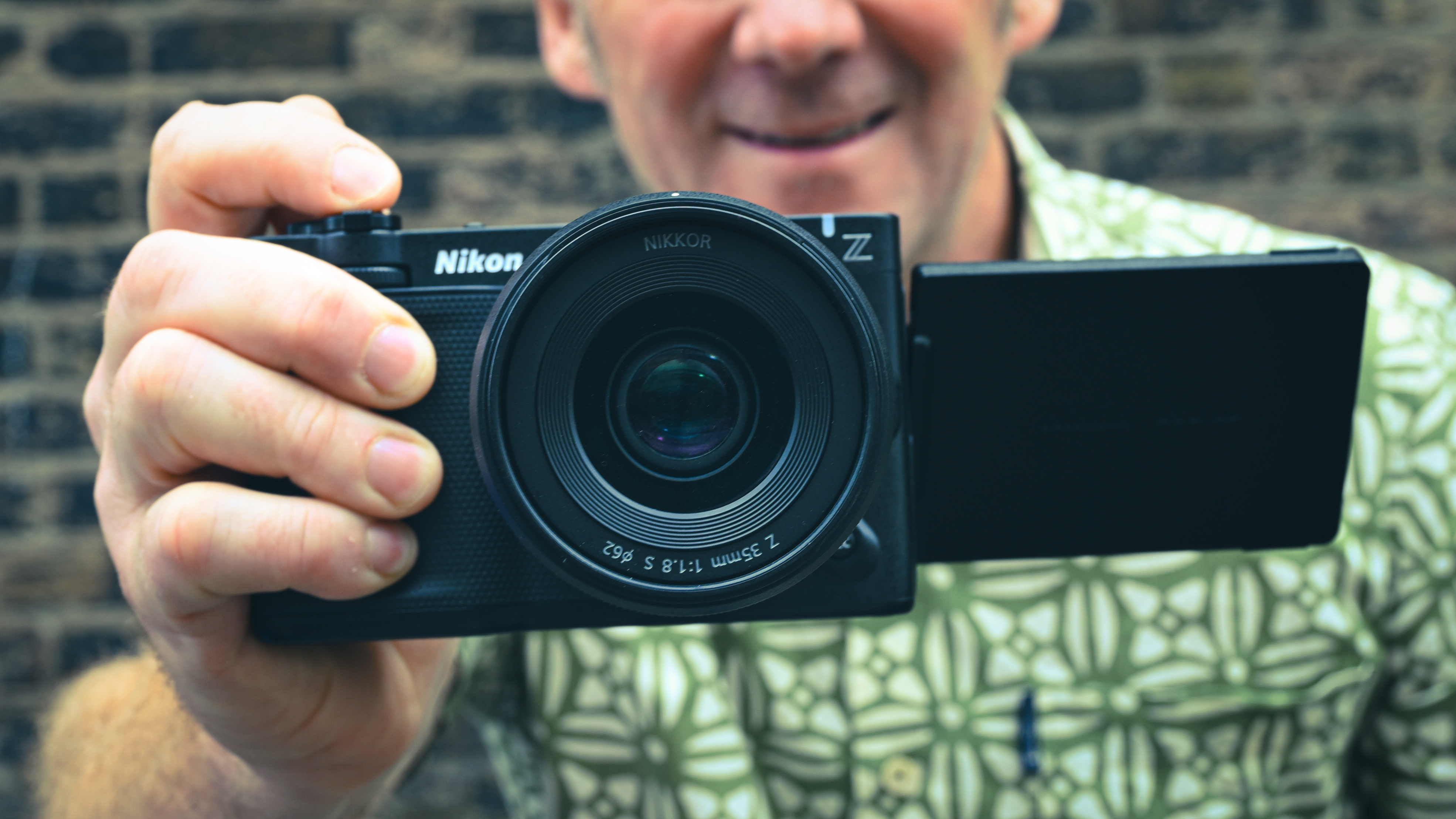 Videographer holding the Nikon ZR in front of a brick wall