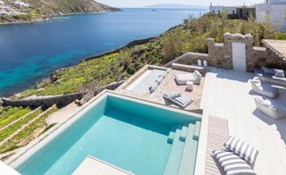 Outdoor lounging areas and infinity pool overlooking the Aegean Sea