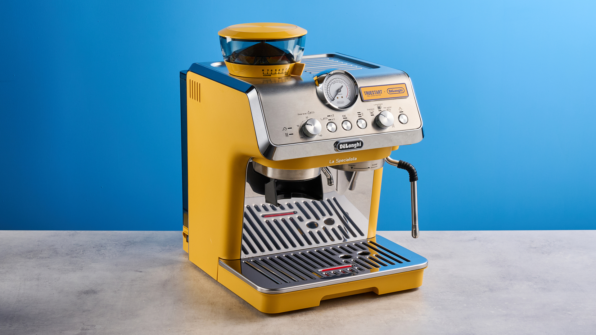 the de&#039;longhi la specialista arte evo special edition truestart edition, with yellow body, showing the espresso machine attachments like tamper, tamping collar, grinder, and control buttons