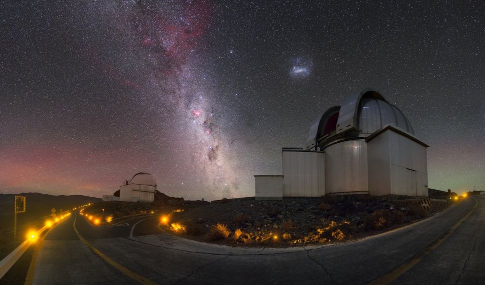 The Milky Way galaxy and one of its cosmic neighbors shimmer over the La Silla Observatory in Chile in this night sky photo by European Southern Observatory photographer Petr Horálek. That galactic neighbor is a dwarf galaxy known as the Large Magellanic Cloud, and directly beneath it is the 7-foot (2.2 meters) MPG-ESO telescope, which scans the cosmos for high-energy gamma ray bursts, or the most powerful explosions in the universe. The smaller telescope on the left is the 3-foot (1 meter) Schmidt telescope, which has been studying galaxies, star clusters, dwarf planets and supernovas for nearly 50 years.