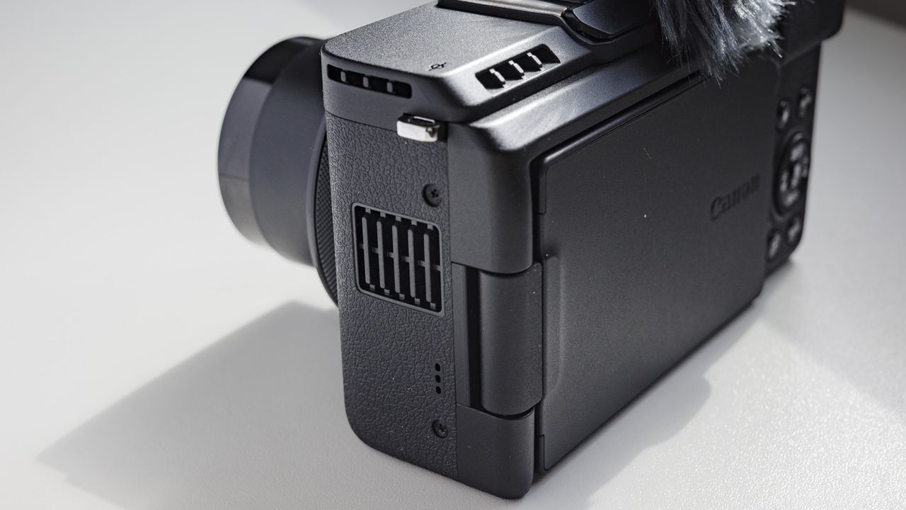 Closeup of Canon PowerShot V1 compact vlogging camera's cooling vents, on a white desk