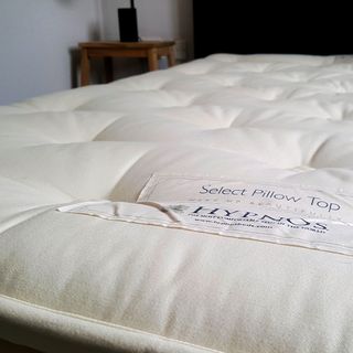 A close up of the Hypnos Select Pillow Top mattress labels and hand tufted surface