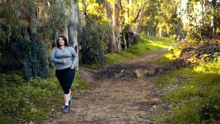 A plus-size hiker on a forest trail