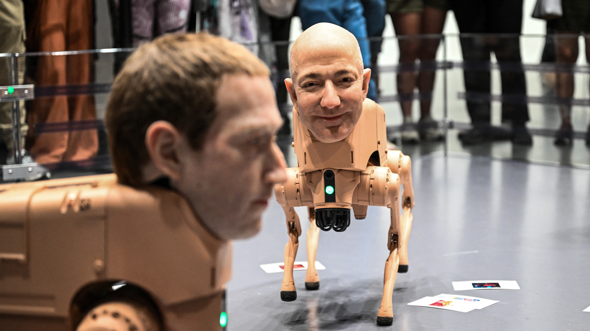 Two dog-like robots with the heads of Mark Zuckerberg and Jeff Bezos