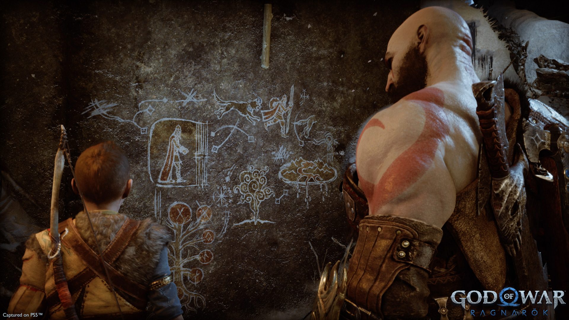 Kratos and Atreus look at some runes and carvings