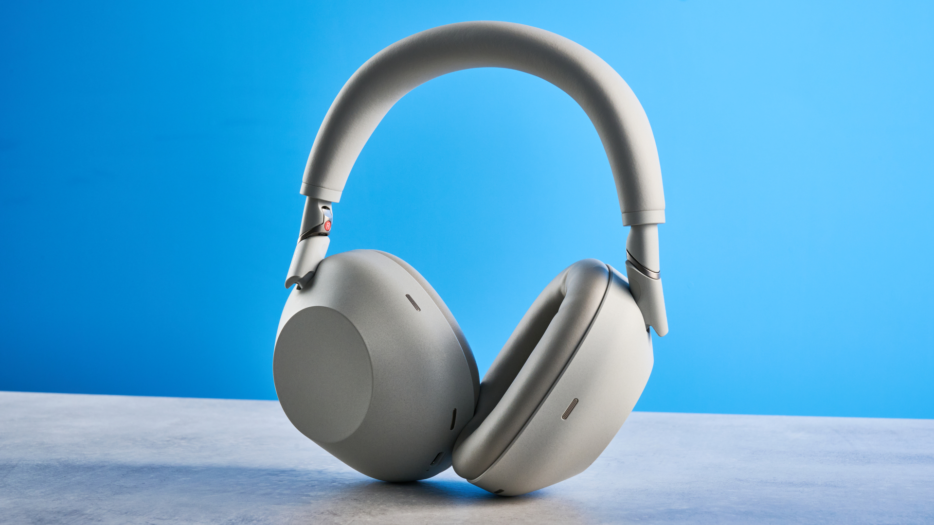 the sony wh-1000xm6 headphones in beige photographed against the blue tom's guide background