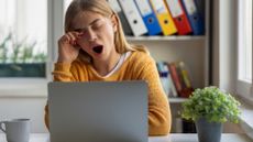 a woman yawns at her desk