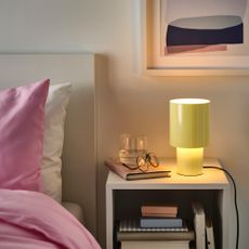 IKEA SPETSBOJ lamp in yellow on a bedside table