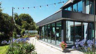 modern glass and grey flat roof extension leading onto patio and garden