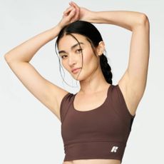 Woman holding hands above her head wearing chocolat Forme Power+ Bra