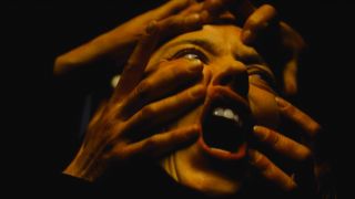 Sydney Sweeney screams while being held down by a mass of hands in Immaculate.