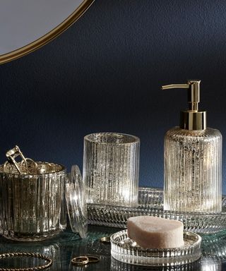 Silver bathroom accessories such as soap dispenser and toothbrush pot