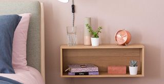 pink bedroom with floating shelf as a nightstand to show how to organize a small bedroom
