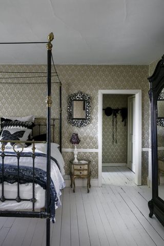 Daisy Lowes gothic vintage bedroom with four poster bed and white painted floorboards