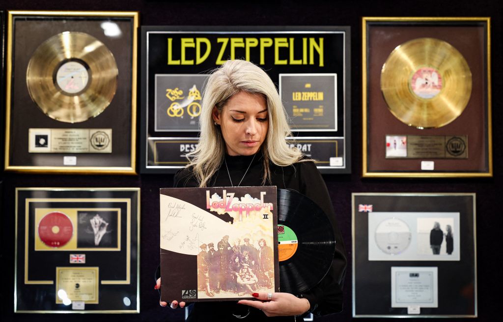 An auction house employee holds an autographed copy of the Led Zeppelin II record album