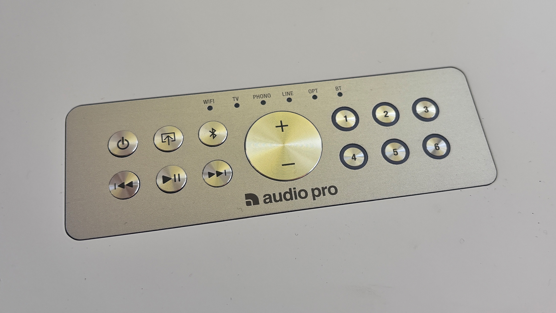Audio Pro C20 W wireless speaker remote control on white surface