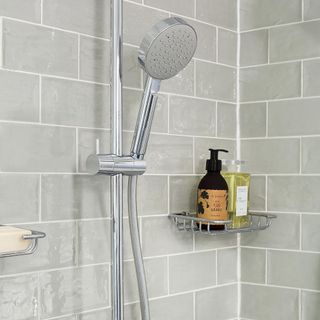 bathroom with grey brick tile wall and shower with shelf