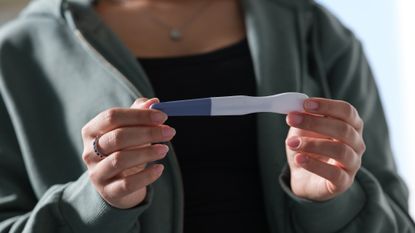 A woman holds a pregnancy test