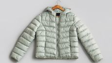 Light green down jacket on gray background