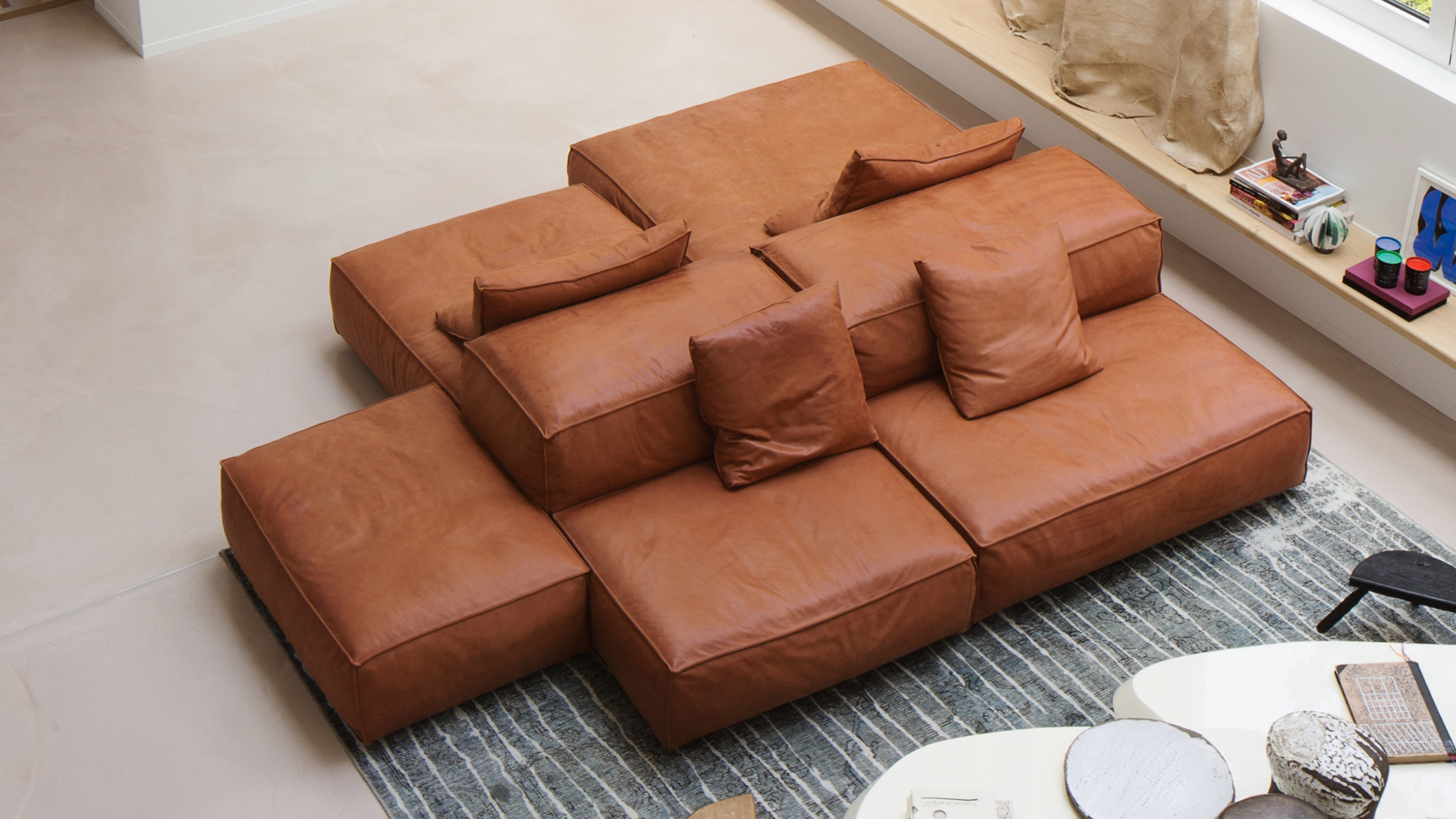 A sofa island comprised of brown leather modular seating components.