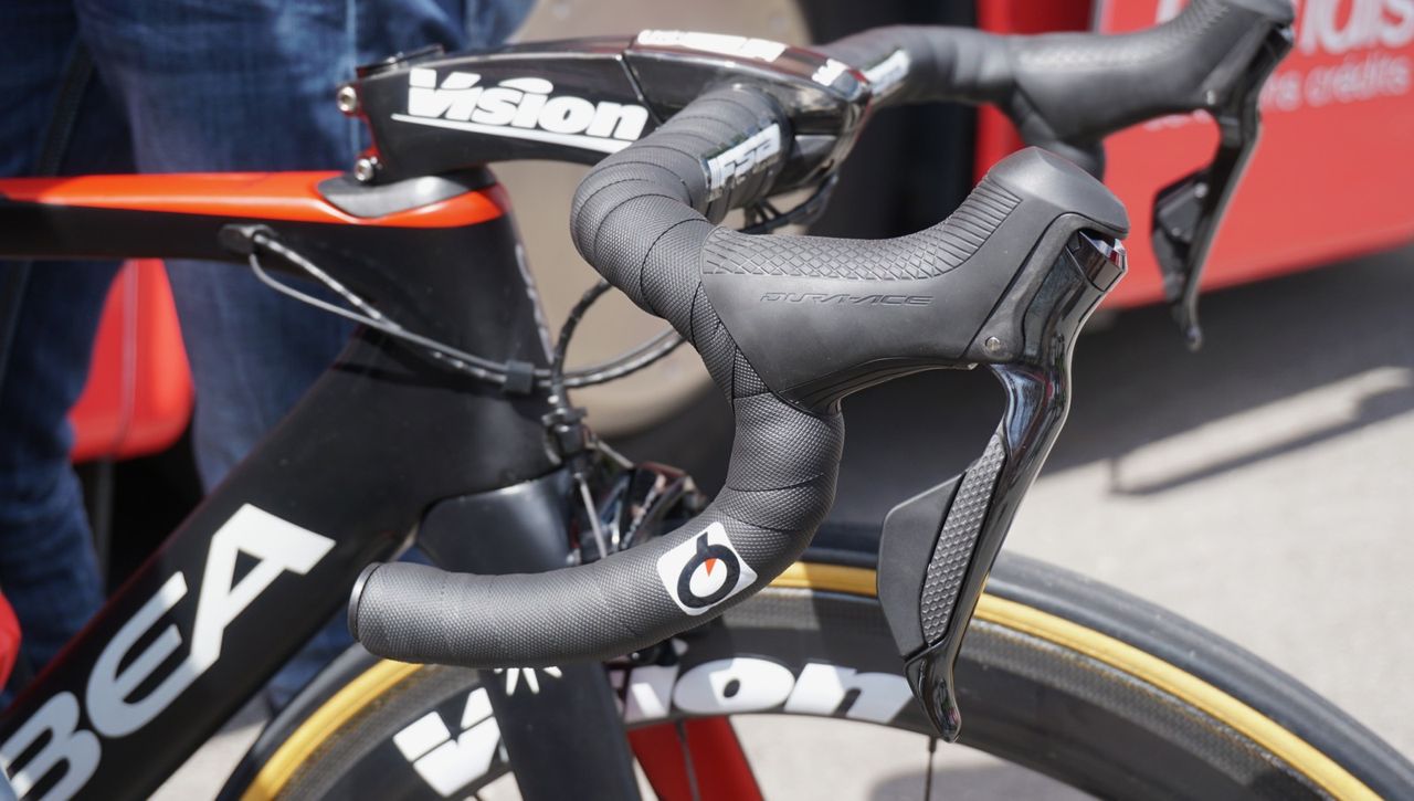 The rear-most button on the new Di2 levers are elongated enough that, on a compact bar, you can hit them with a slightly extended knuckle to shift while sprinting