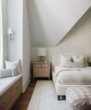 bedroom with soft textiles and colors and bed under the eaves