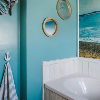bathroom with white bathtub and blue wall