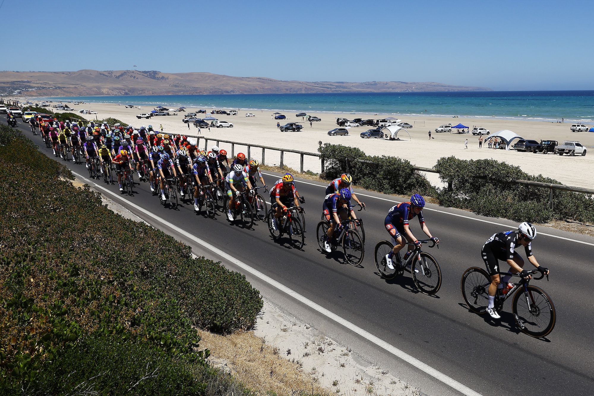 WILLUNGA, AUSTRALIA - JANUARY 17: A general view of the peloton competing at Aldinga Beach landscape during the 10th Santos Women's Tour Down Under 2026, Stage 1 a 137.4km stage from Willunga to Willunga 134m / #UCIWWT / on January 17, 2026 in Willunga, Australia. (Photo by Con Chronis/Getty Images)