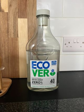 A bottle of Ecover laundry detergent on a black kitchen counter.