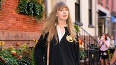 A picture of Taylor Swift in a blue cardigan outside a brick building