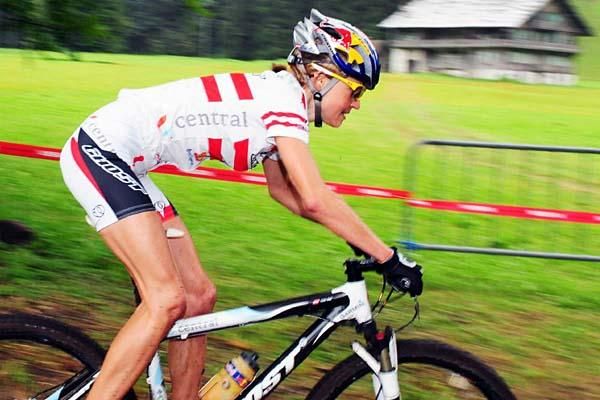 Elisabeth Osl (Central Ghost) rides on a flat section of the course.