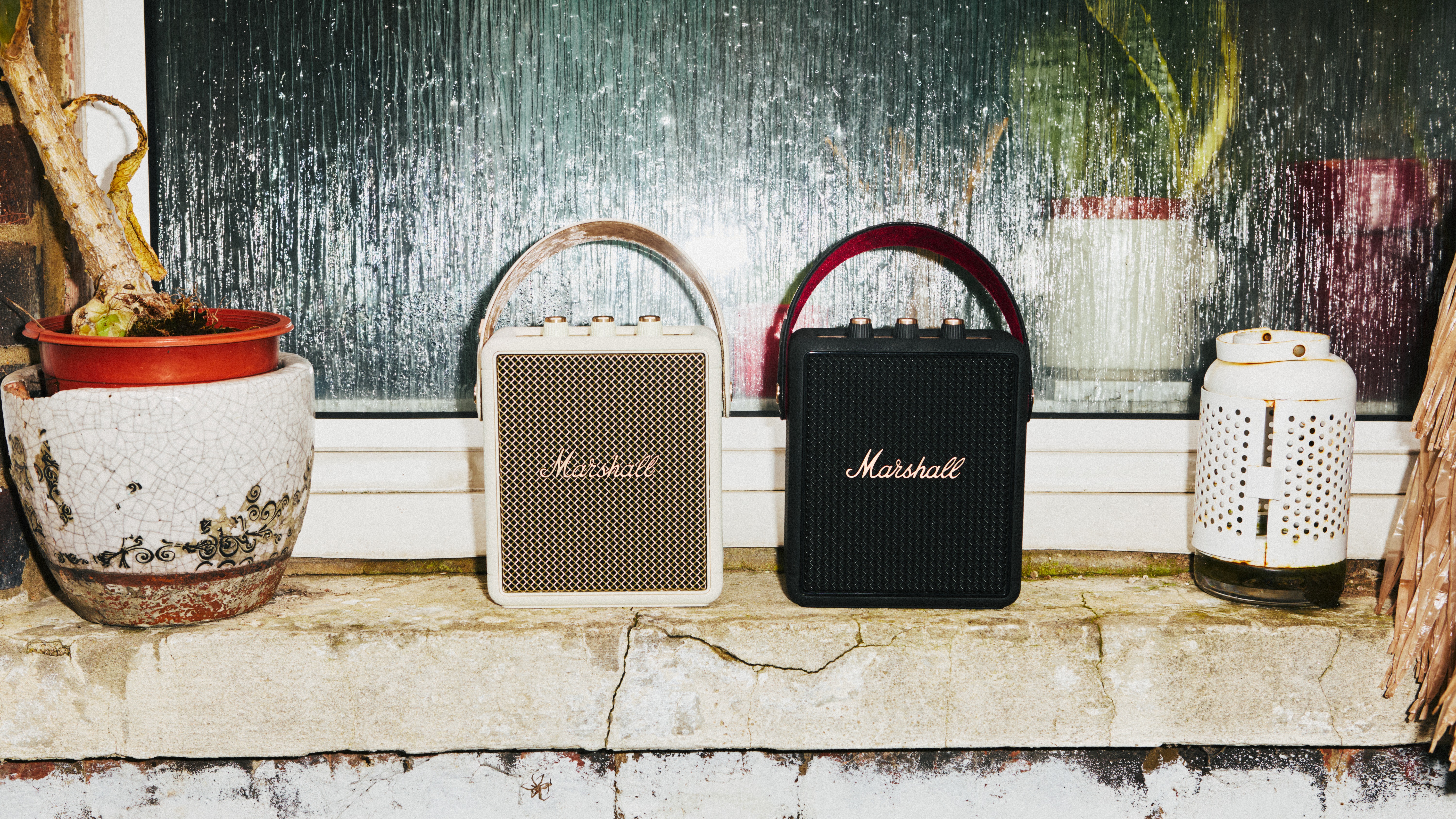 Two Marshall Stockwell III speakers, one in cream and one in black and gold