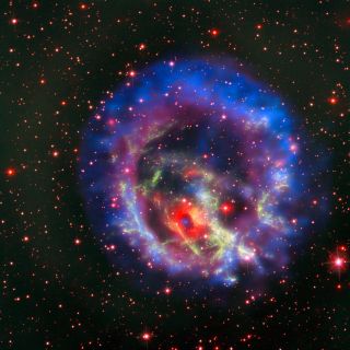 This is a composite image of the region around supernova remnant 1E 0102.2-7219, seen in green; the first isolated neutron star with a weak magnetic field ever identified outside the Milky Way is shown in blue. The observations come from the NASA/ESA Hubble Space Telescope and NASA's Chandra X-ray Observatory, and the red ring with a dark center is from the MUSE instrument on the European Southern Observatory's Very Large Telescope.
