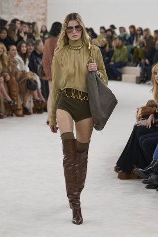 Chloé model carrying a slouchy handbag on the runway